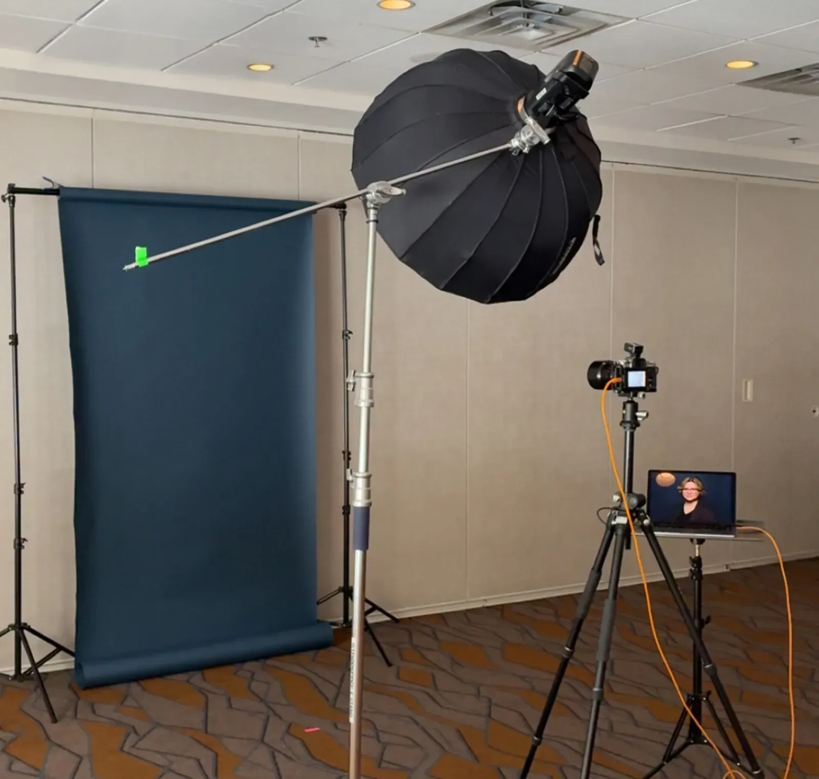 On-location headshot booth setup at a Calgary venue - backdrop, studio lighting, and tethered camera